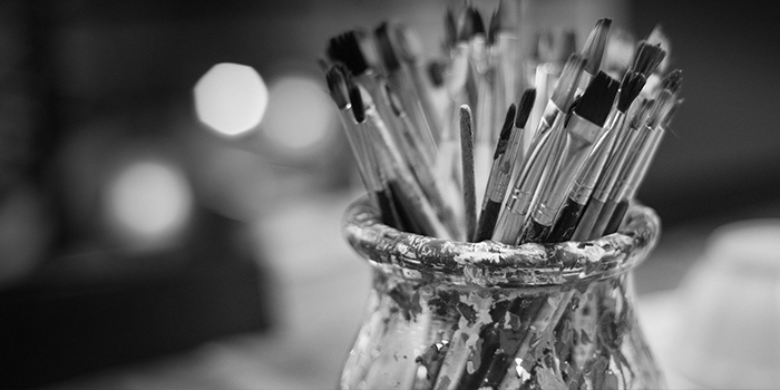 Paint brushes inside a container.