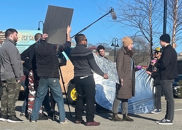 Production crew and actors on location shooting film