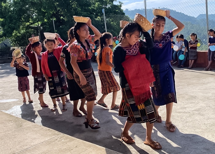 Guatemalan girls carrying baskets on their heads