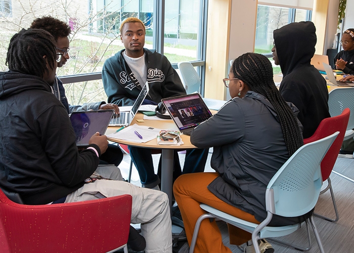 Students share common tables to work on school assignments at Student Support Services.