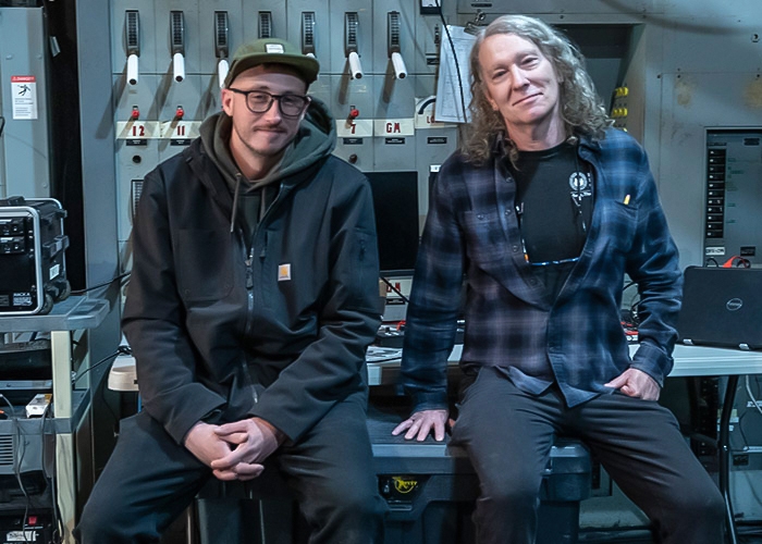 Chris and Alan sit next to each other backstage