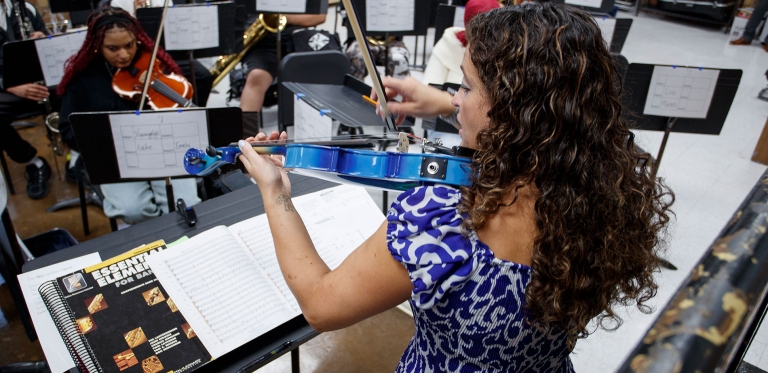 Danielle Lucini playing violin along with concert band 