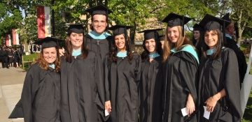 Graduate students on campus in their caps and gowns for commencement