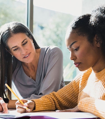 Counselor helping student at table