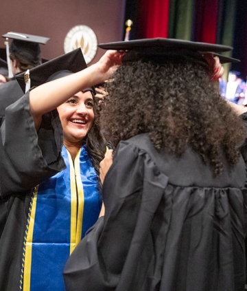 Student capping another student at Cap and Gown convocation