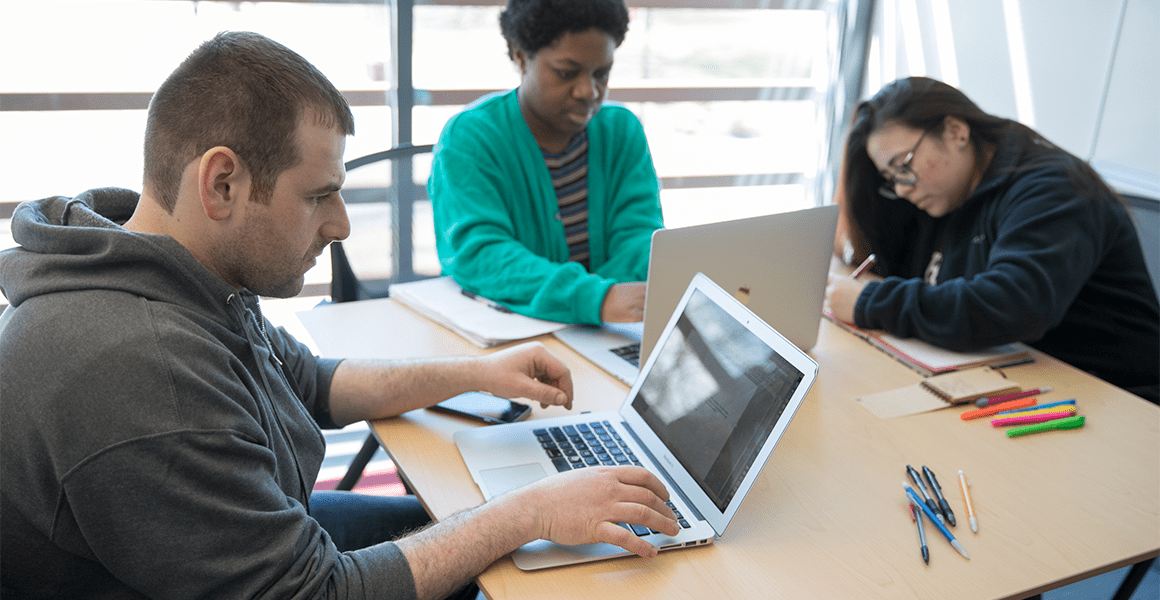 Three students working independently at a table