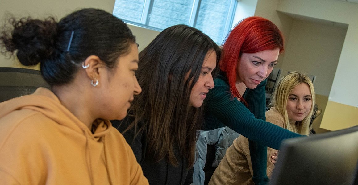 Students working with professor in psychology class