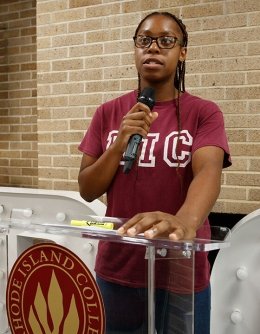 Jacqueline Joly at podium practicing public speaking 