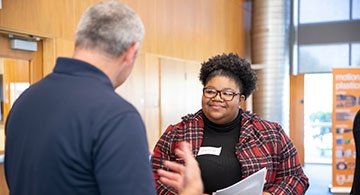 Business student talking with employer at on-campus career fair