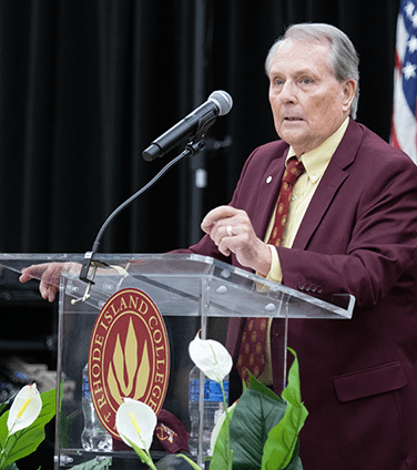 President Warner speaking at podium