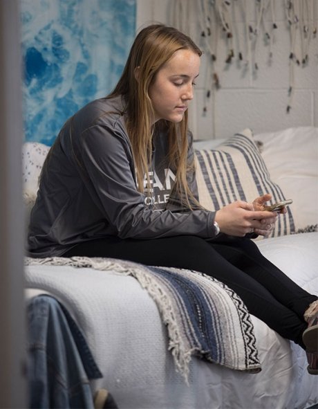 Sitting on bed in dorm room