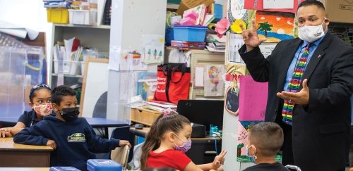 Providence Schools Superintendent Javier Montanez stands in front of an elementary school class demonstrating sign language