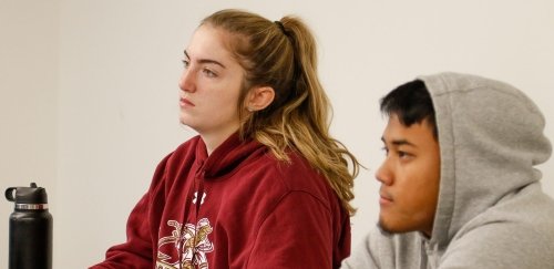 Students listening at table in accounting class