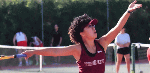 Tennis player outstretches her arms to hit ball