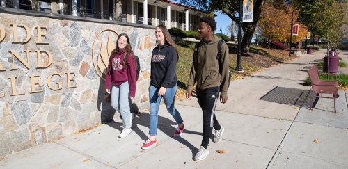 Three students walking together on the quad in fall