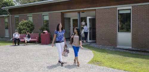 Students walking and sitting near the School of Social Work building