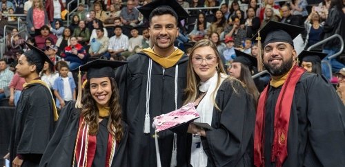 Proud graduates smiling and posing together in their caps and gowns