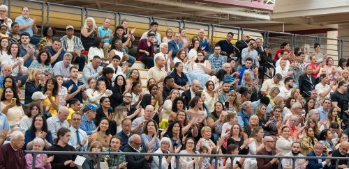 Commencement ceremony guests clapping in the stands