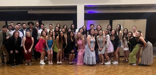 Group of smiling RIC students dressed in formal attire in student union ballroom