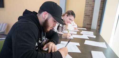 Students at table, writing