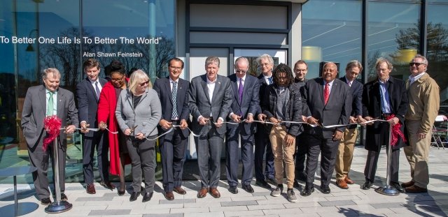 A group of state and educational leaders cuts a ceremonial ribbon outside the newly renovated Horace Mann Hall.