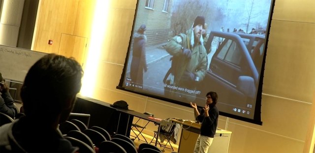 Prof. Bohlinger lectures in front of class, with image of film behind him.