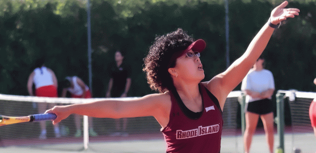 Tennis player outstretches her arms to hit ball