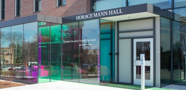 Exterior photo of the front entrance of Horace Mann Hall, showing the quote from Alan Shawn Feinstein that reads, "To Better One Life is to Better the World"