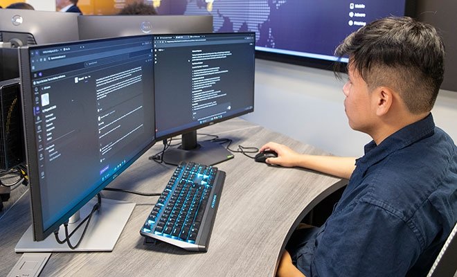 Student working at dual computer monitors
