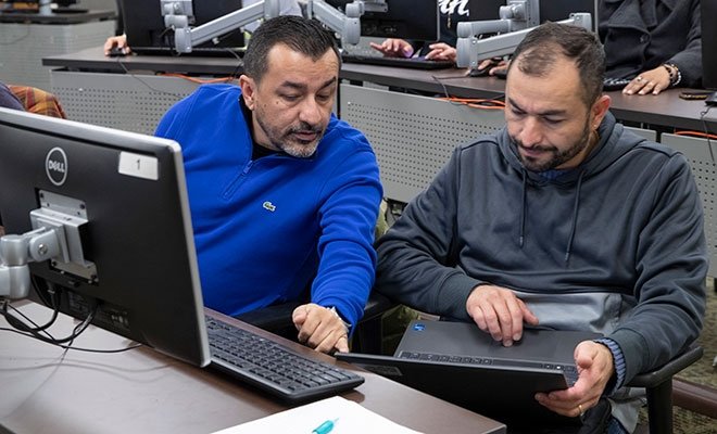 Person assisting another person in computer lab