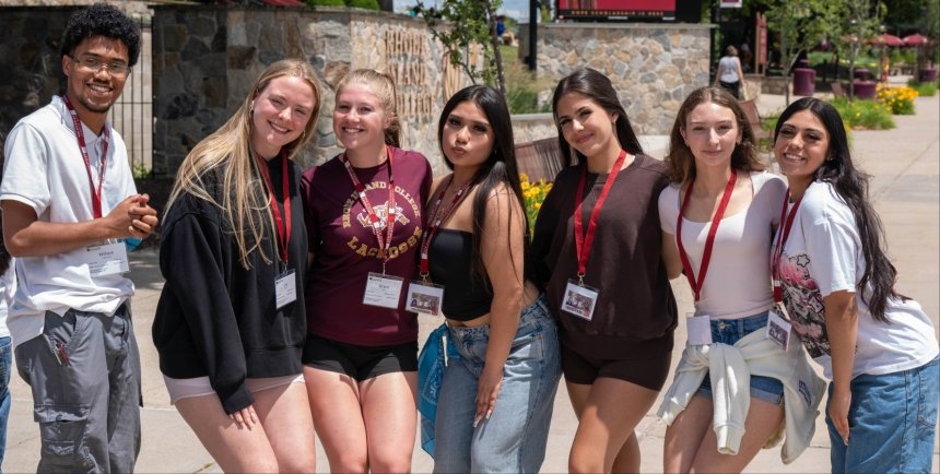 Six female and one male RIC student stand together on the quad during summer orientation.